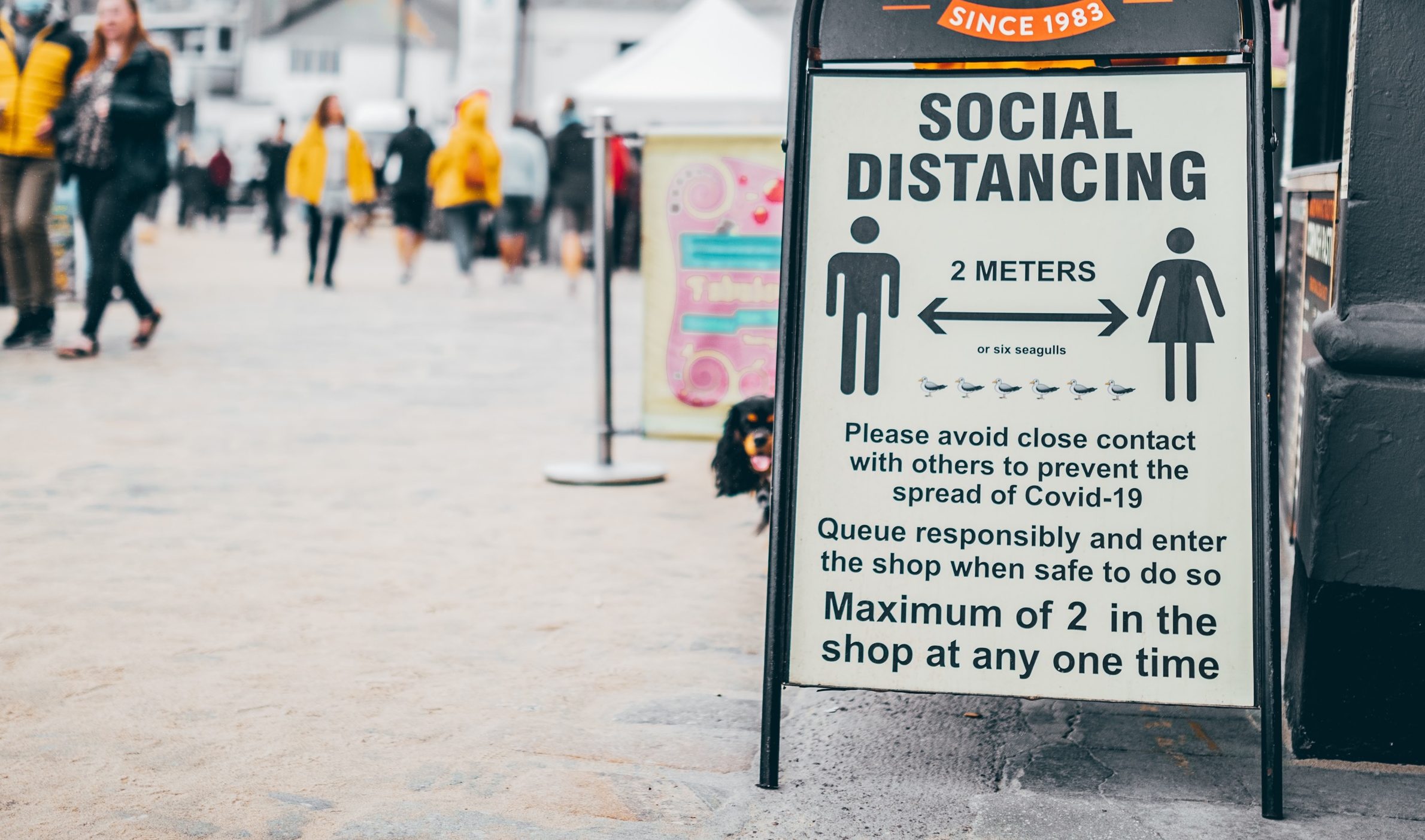 A social distancing sign outside a bakery. Photo by Andy Holmes on Unsplash