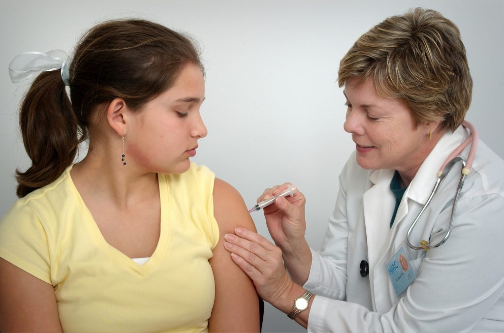 A young woman receives a vaccine shot. Photo by CDC on Unsplash.com