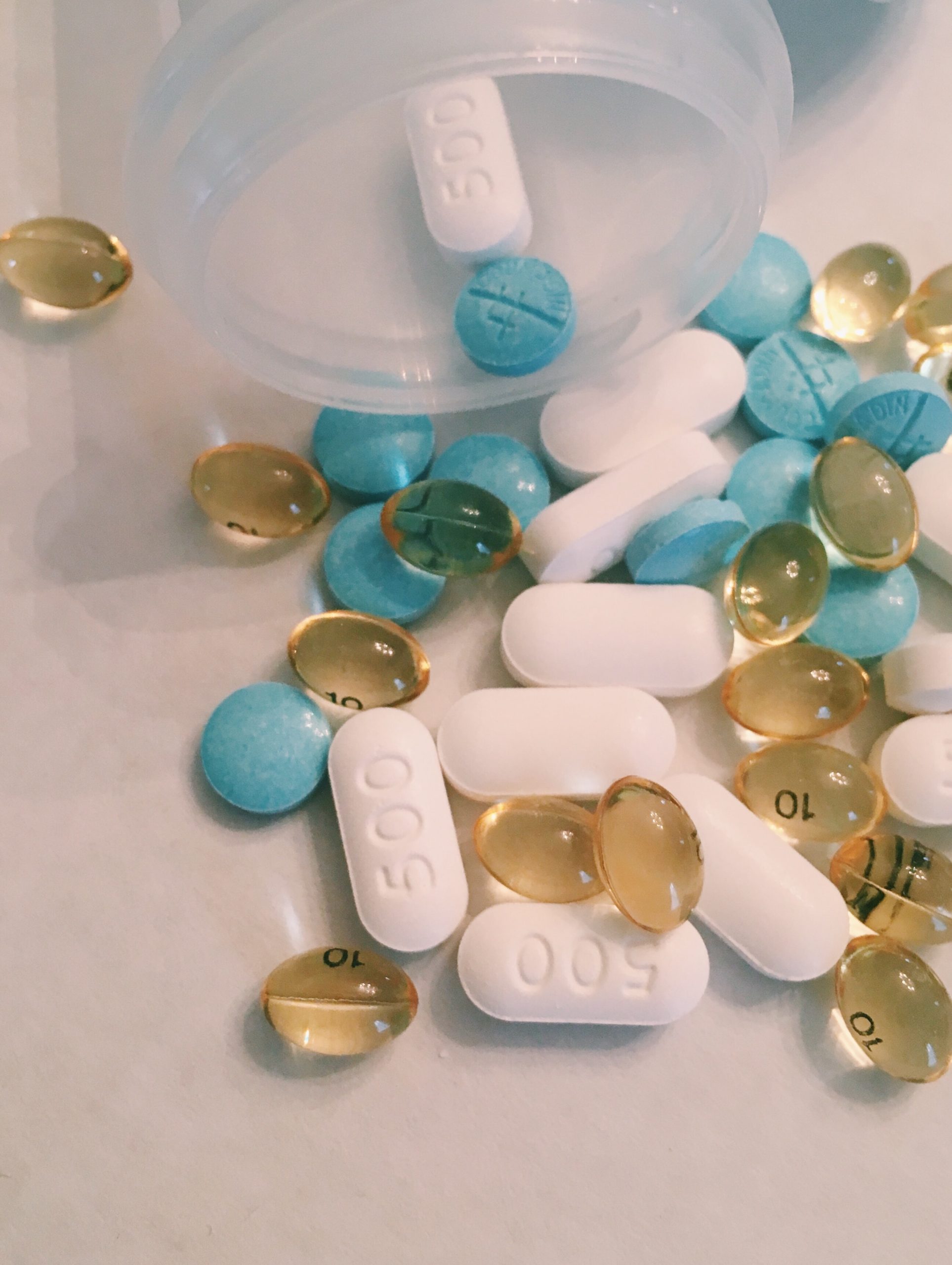 Blue, white and clear pills. Photo by pina messina on Unsplash