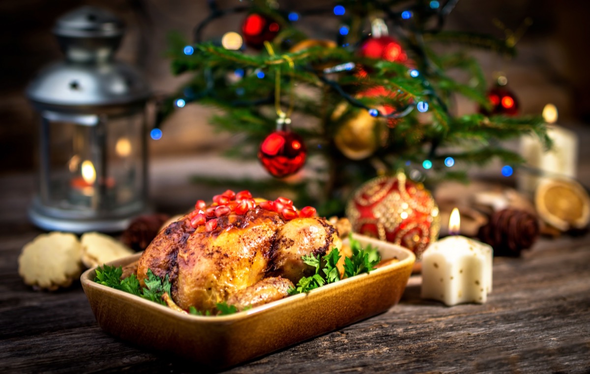 A roaast turkey with a christmas tree behind. Photo from Adobe Stock.