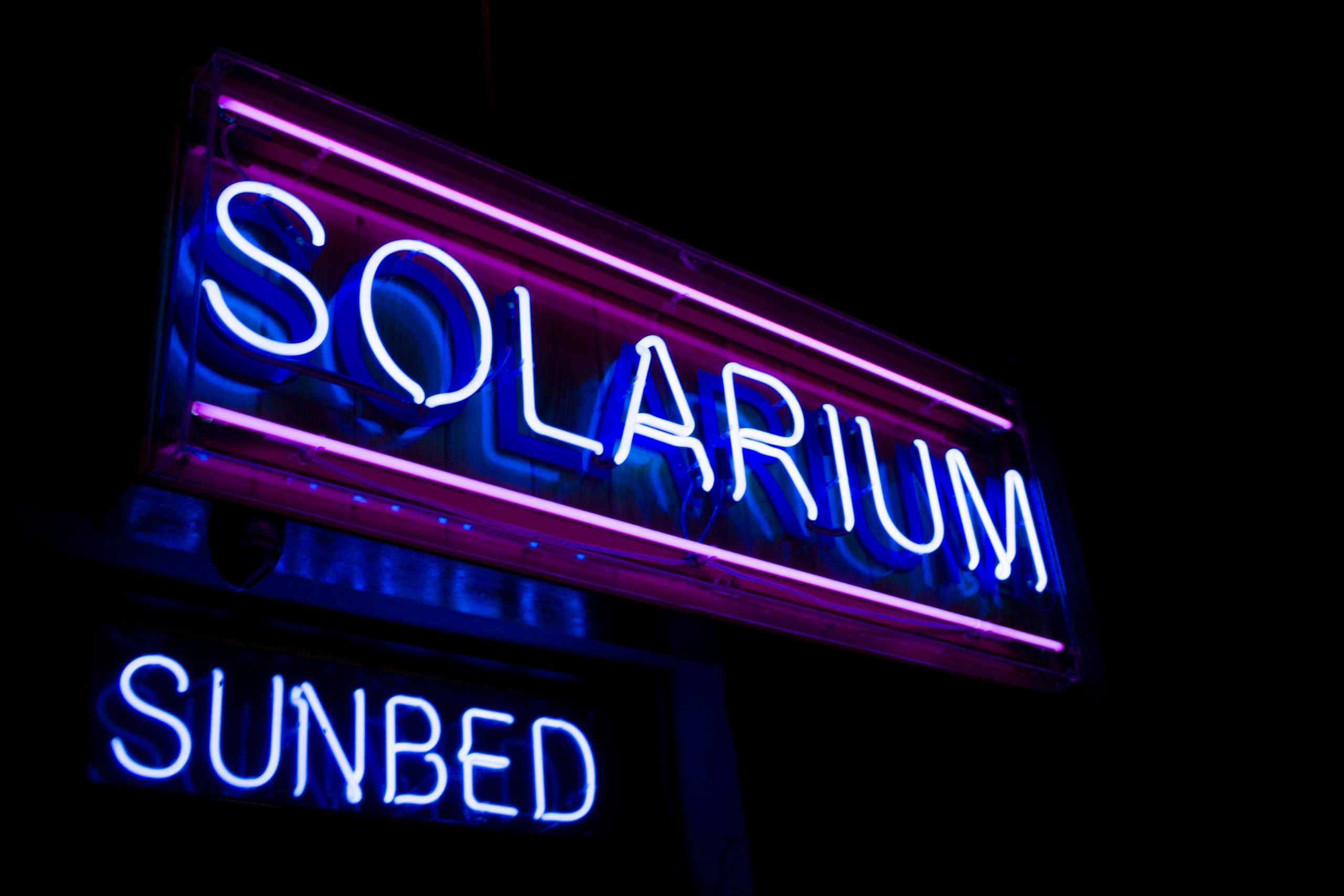 Neon signs saying 'solarium' and sunbed' Photo by samuel-mcgarrigle on Unsplash.com