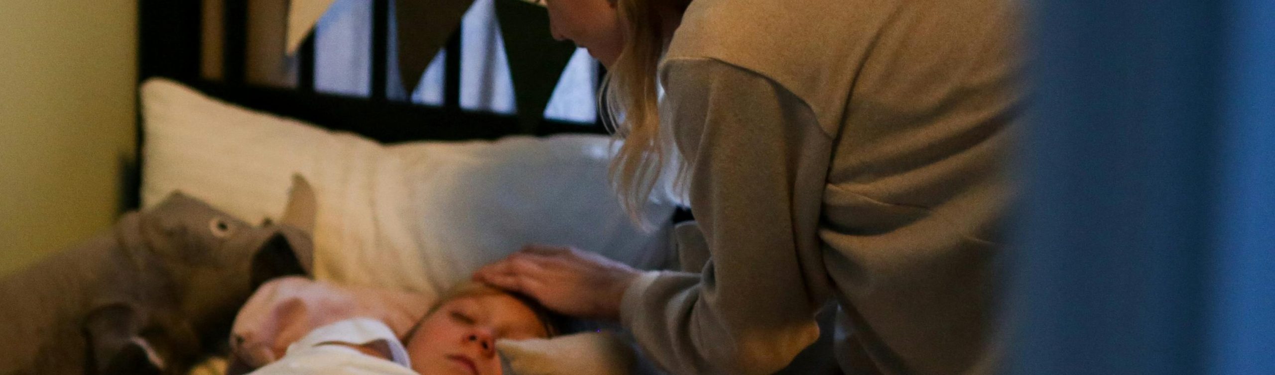 An ill child in bed is comforted by a parent. Image by Cottonbro Studio on Pexels.com